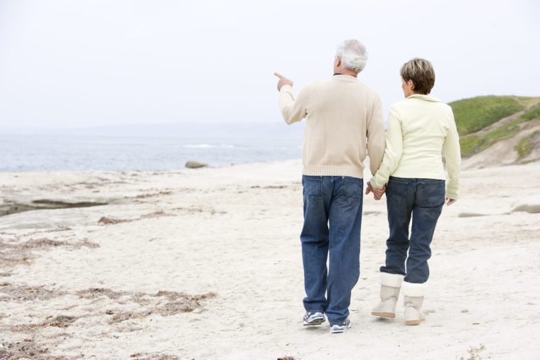 Et eldre par går tur på strand