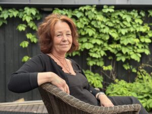 Anne Amlund Olafsbye sittende i en stol utenfor kurslokalet på Modum Bad.