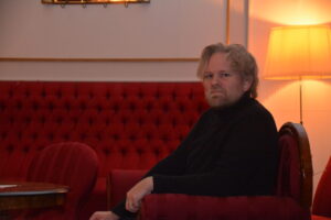 Lege Mikkel Eielsen sitter i en stol i Festsalen
